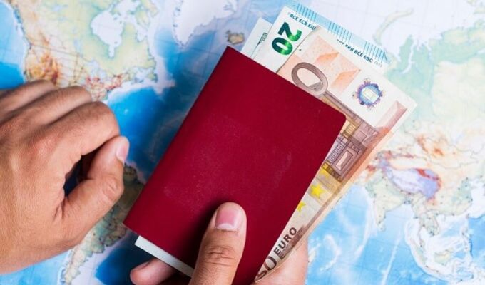 Ilustracja przedstawiająca paszport w którym znajdują się banknoty