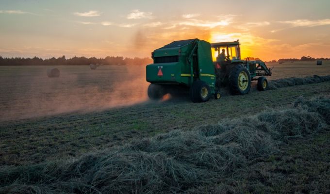 Zdjęcie przedstawiające traktor zbierający słomę